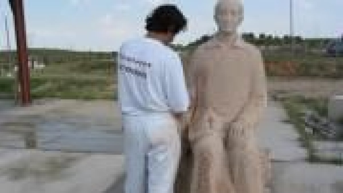 Un operario trabaja en la restauración de la estatua de Panero