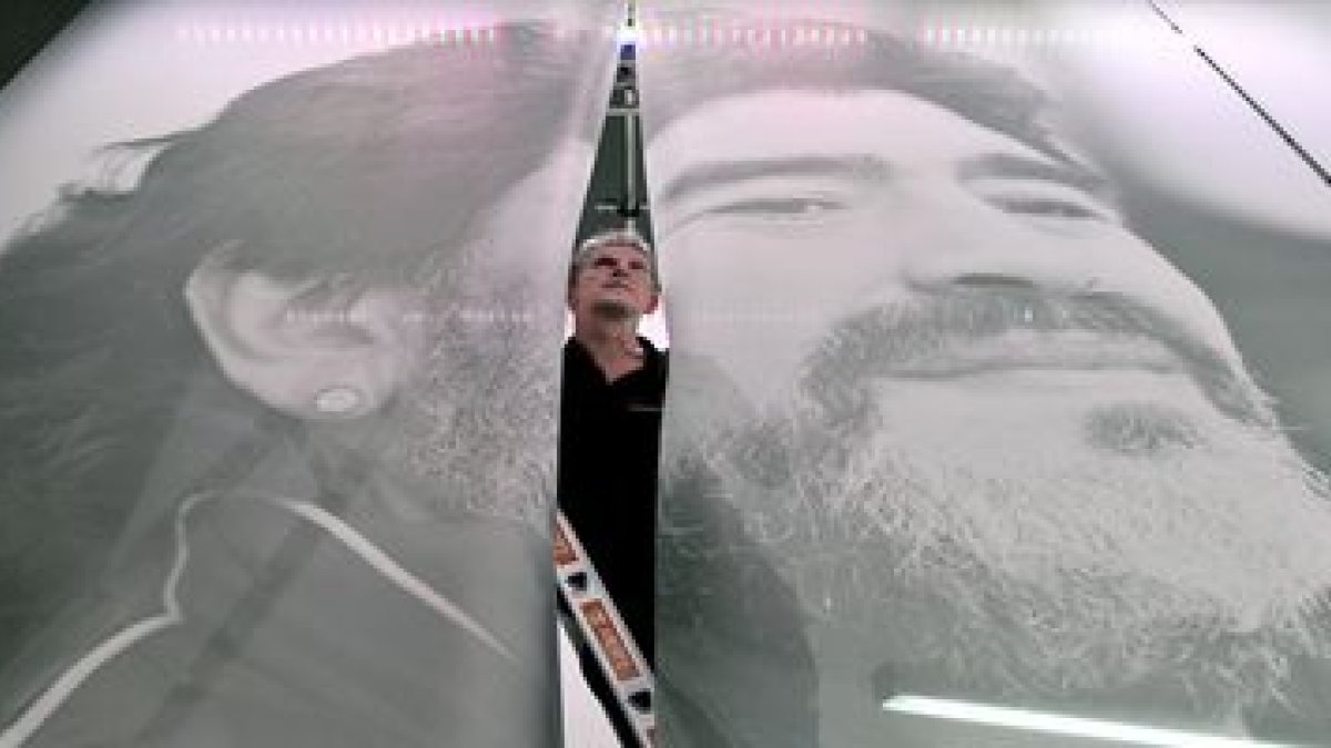 Un operario mientras da los últimos retoques a un retrato de Maradona