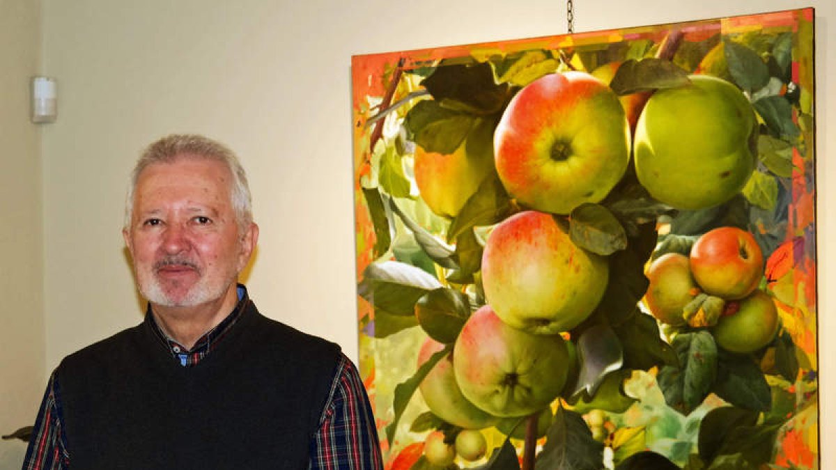 El pintor asturiano José Pérez Collar, junto a una de sus obras expuestas en Bernesga. CUEVAS