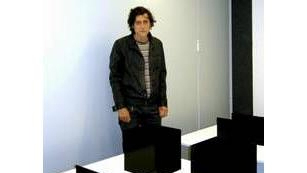 Imagen del artista Juan Manuel Villanueva ante algunas de sus obras
