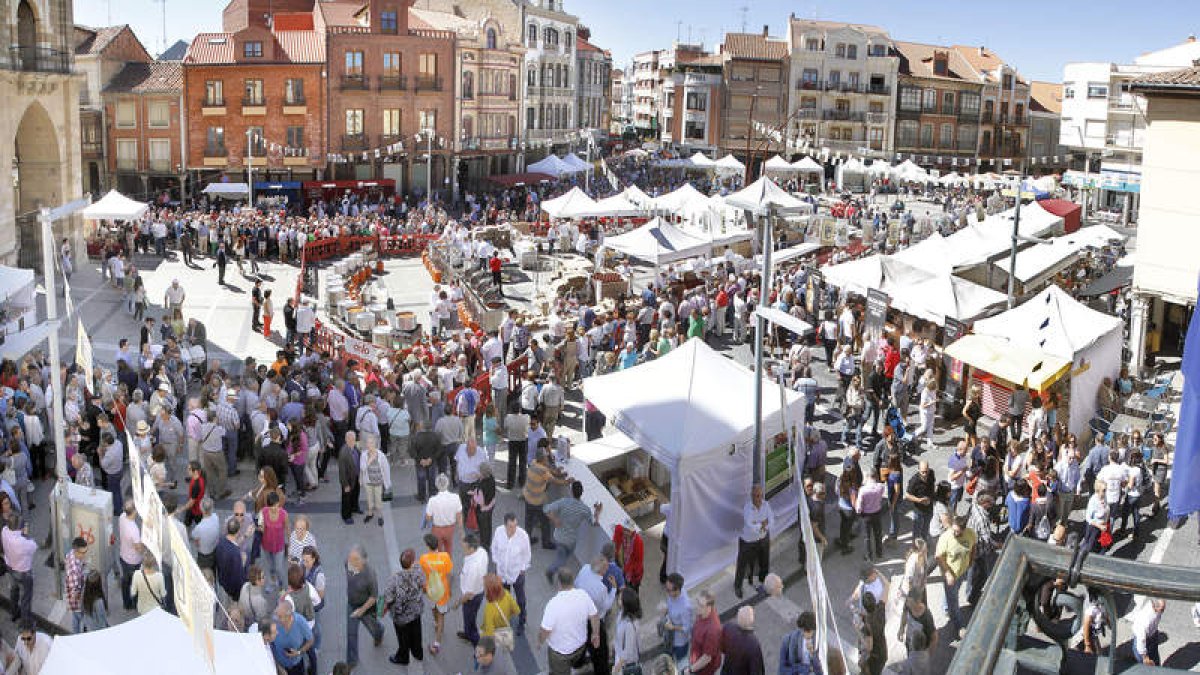 Miles de personas abarrotan la plaza para comprar en la feria y comer las tradicionales alubias.