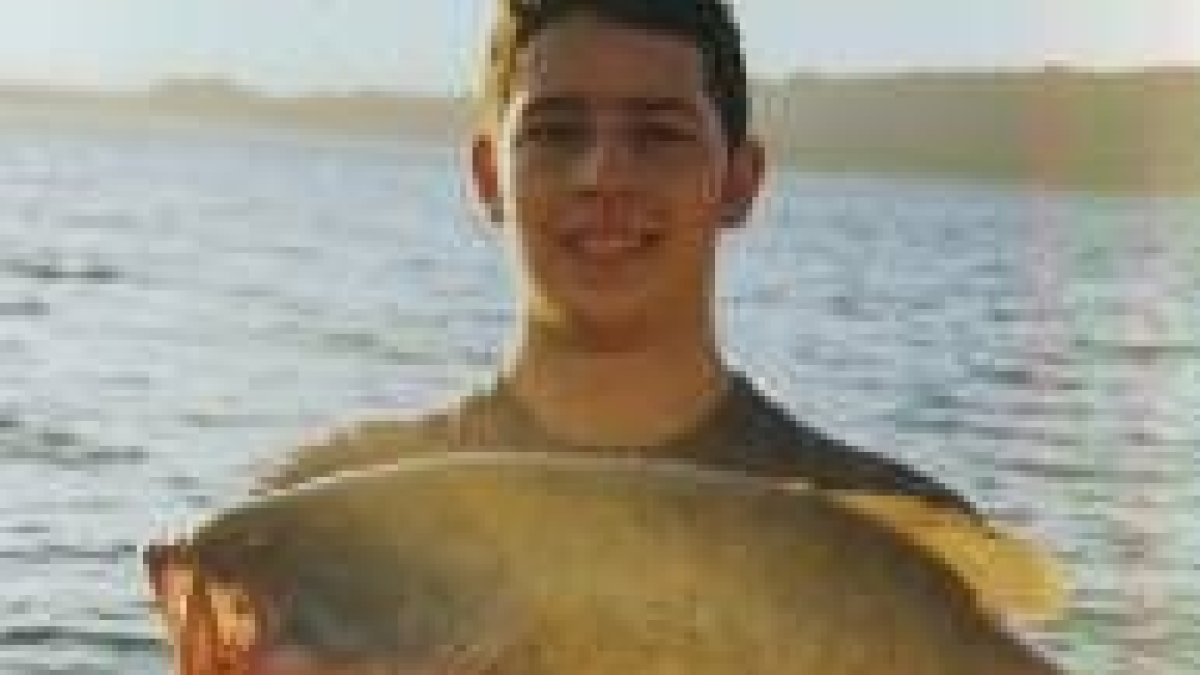 Miguel Fernández sostiene el black bass que pescó en el pantano de Bárcena