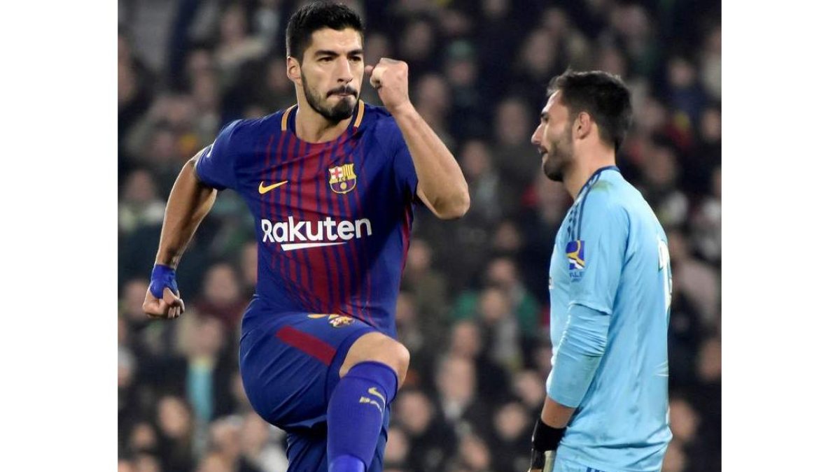 Luis Suárez celebra ante Adán uno de los dos goles que le marcó ayer al Betis. RAÚL CARO