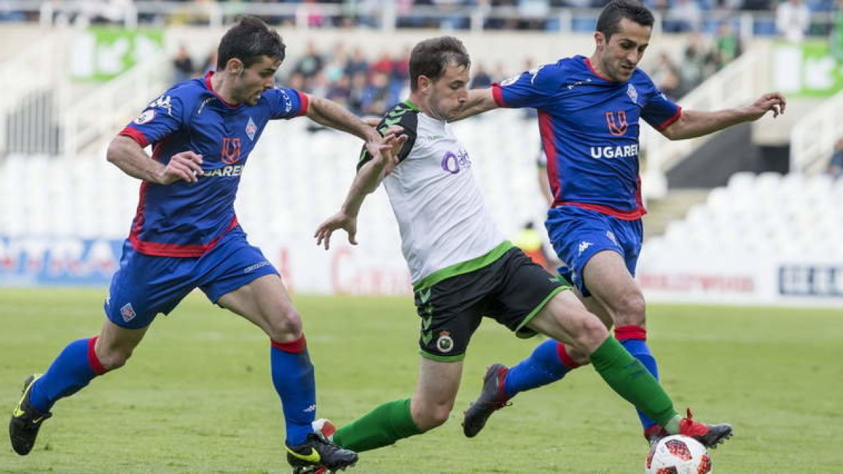 Julen Castañeda, con la elástica del Racing de Santander, se lleva un balón a pesar de la oposición de los contrarios. ROBERTO RUIZ / EL DIARIO MONTAÑÉS