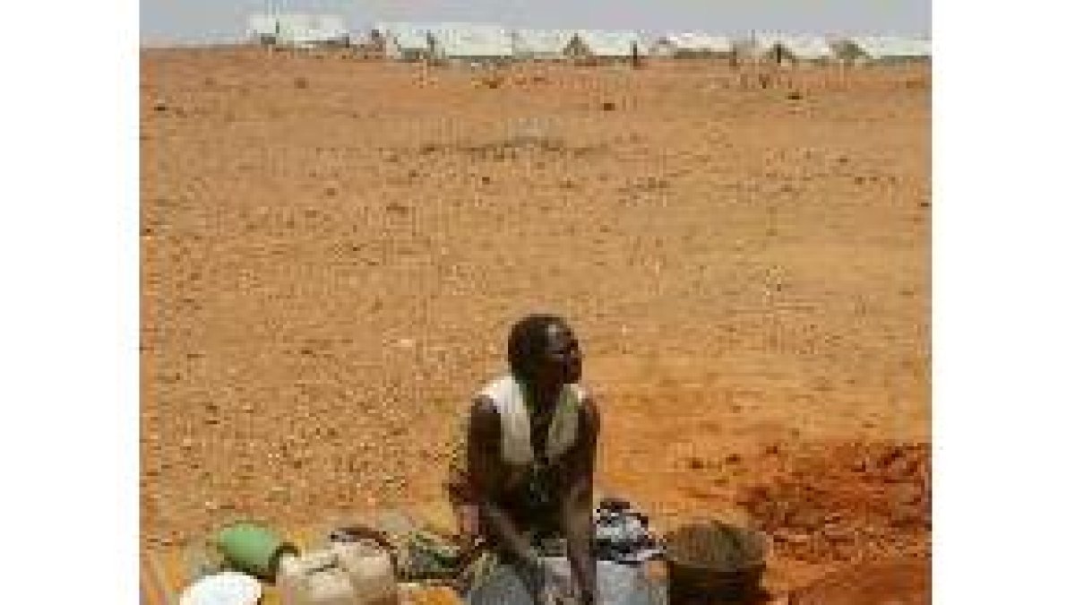Una sudanesa refugiada lava su ropa cerca de unas tiendas de campaña en el Chad