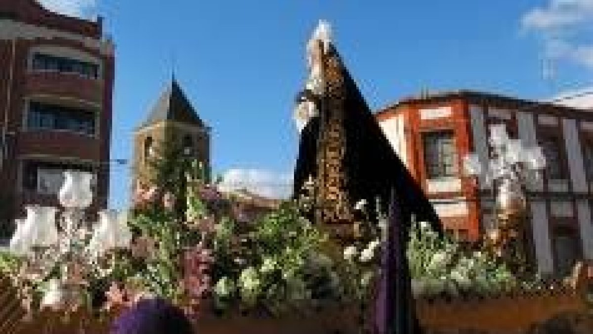 La Soledad y la torre de la iglesia de El Salvador, durante la procesión de La Bañeza