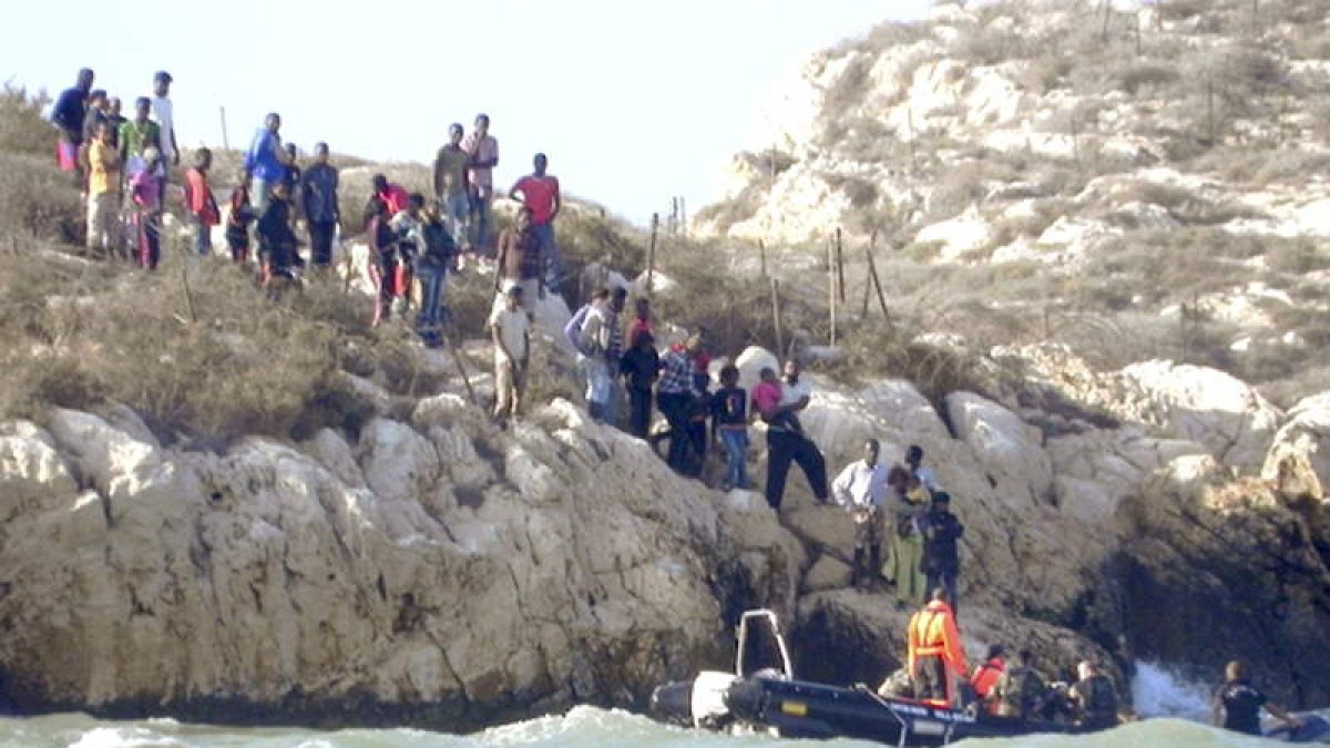 Soldados españoles abastecen de agua y comida a los 81 inmigrantes.