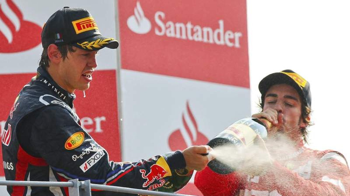 Vettel celebra en el podio junto a Fernando Alonso su triunfo en Monza que le deja a las puertas de revalidar el título de campeón.