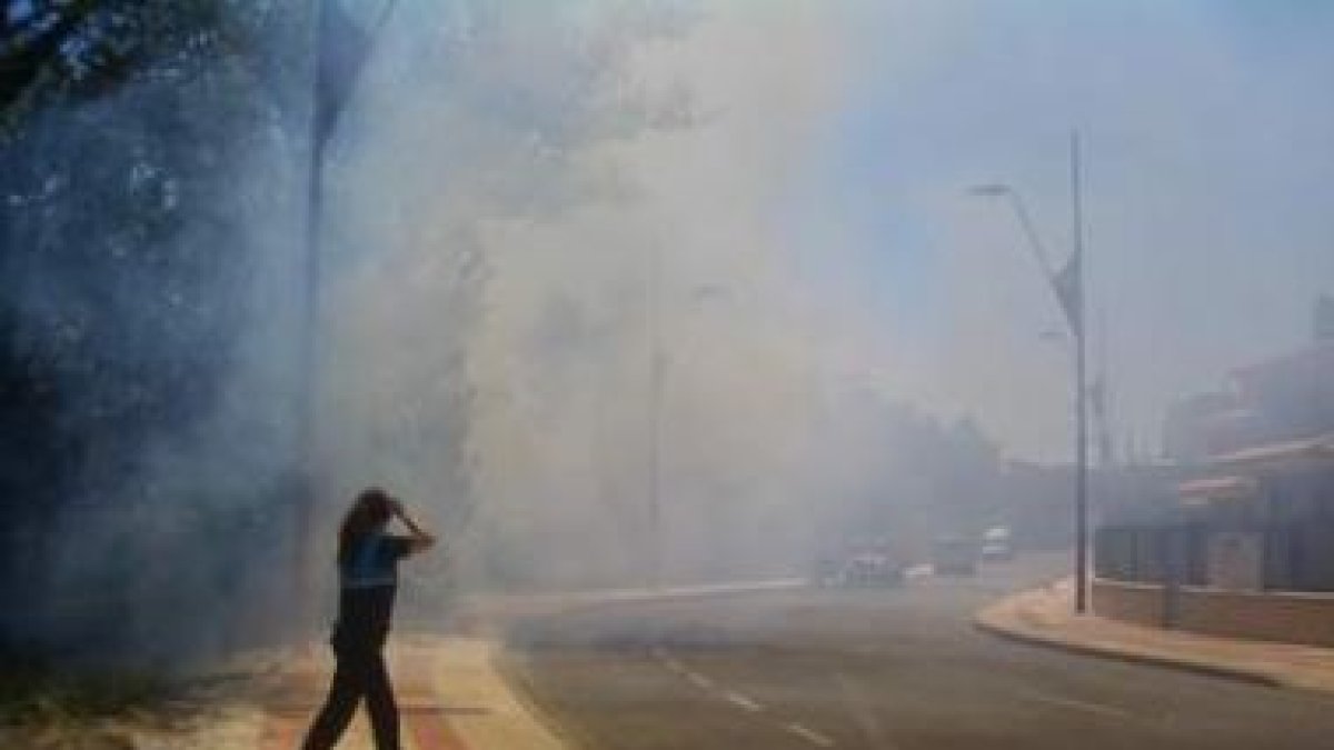 Una agente de la Policía Local de San Andrés trata de alertar por el humo de un incendio.