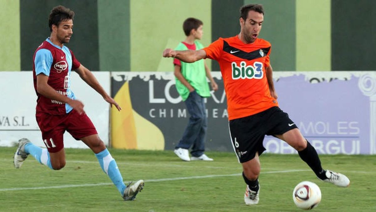 Carlos Ruiz, que ayer no encontró el camino del gol, controla el balón ante la presión de un jugador de la Gimnástica Segoviana en el partido disputado ayer en La Albuera.