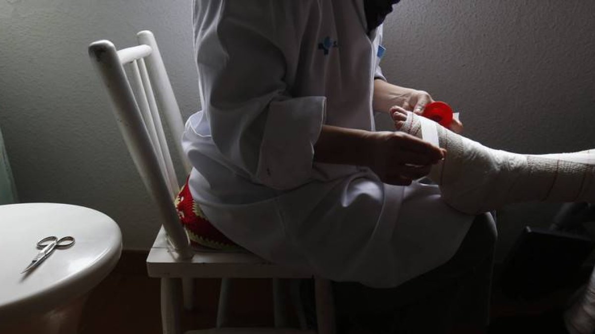 Una enfermera hace una cura a una paciente en Lillo del Bierzo