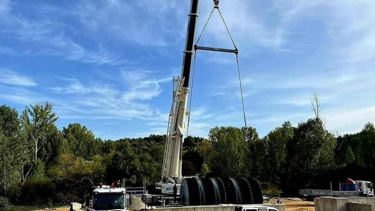 Una grúa de gran tonelaje en el momento de colocar el gran cilindro para depurar las aguas sucias. DL