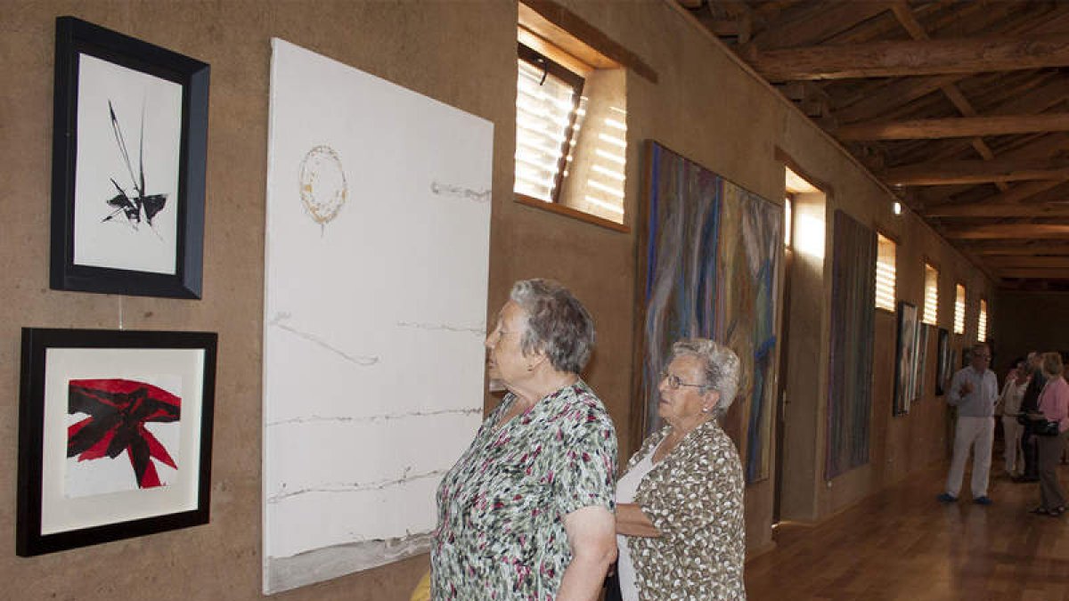 Varias personas observan algunas de las obras, ayer tras inauguración de la exposición.