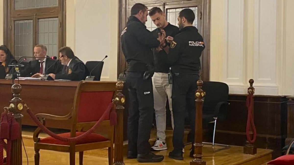 Los agentes esposan al sospechoso tras un receso. MÁZ