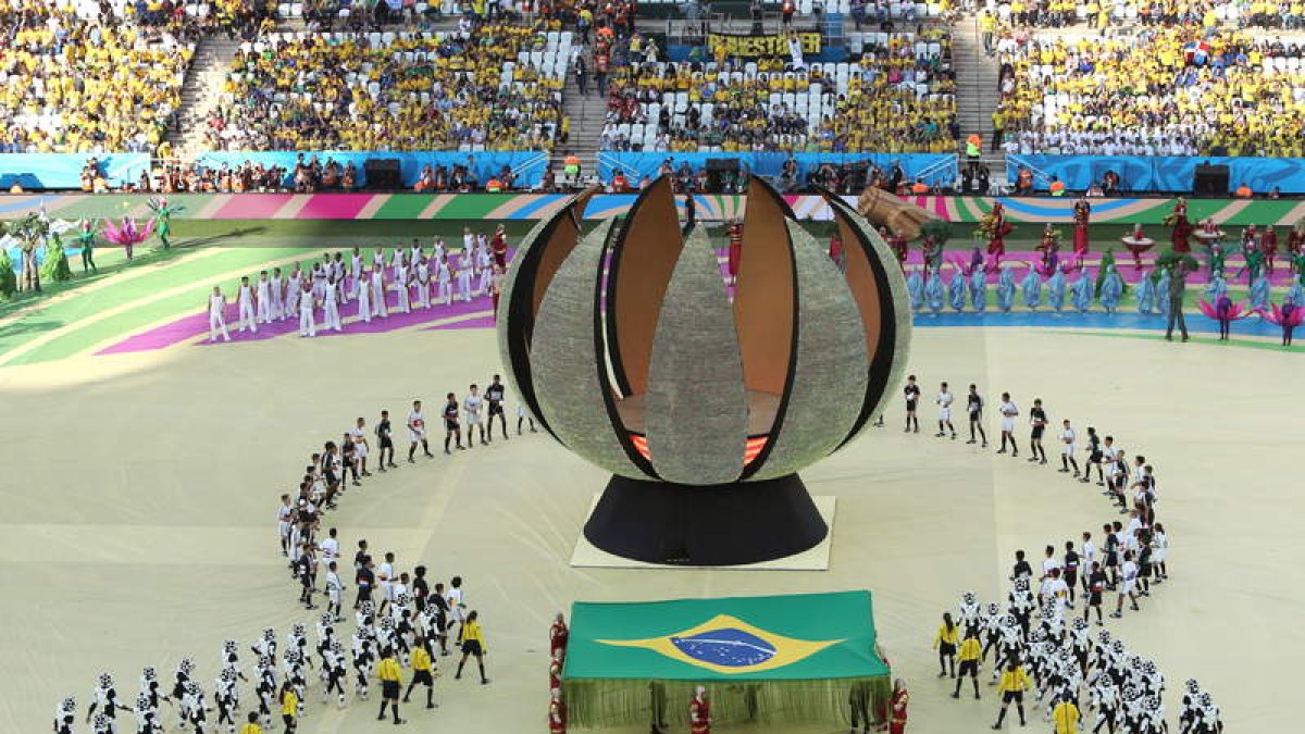 A la izquierda un momento de la gala de inauguración del Mundial. A la derecha, las dos estrellas de la presentación: las cantantes Jennifer López y Claudia Leitte .