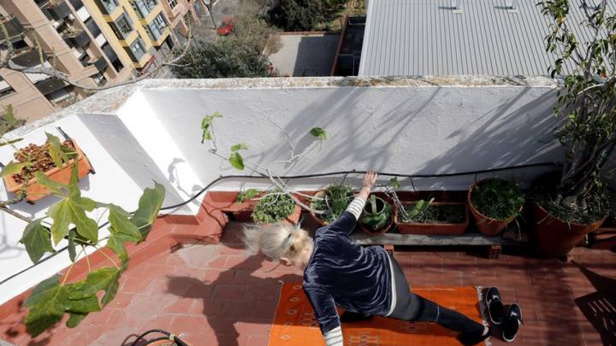 Una mujer practiacndo ejercicio en su terraza, en Valencia. JUAN CARLOS CÁRDENAS