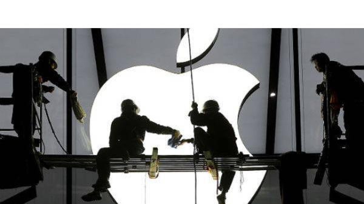 Operarios colocan un logo de Apple en una de las sedes de la compañía.