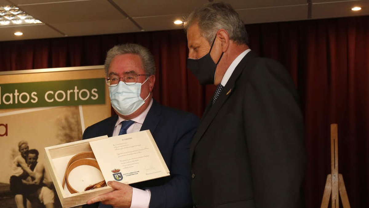 El presidente de la Lucha Leonesa, Ángel Rivero, a la izquierda, recibe un cinto del alcalde de Valdefresno, Carlos Gutiérrez. FERNANDO OTERO