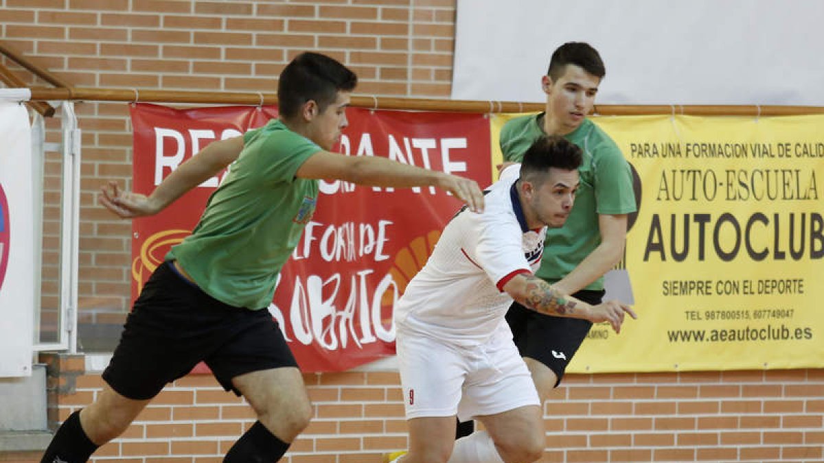 El jugador trepalense Óscar se lleva el balón entre dos jugadores del equipo segoviano. FERNANDO OTERO