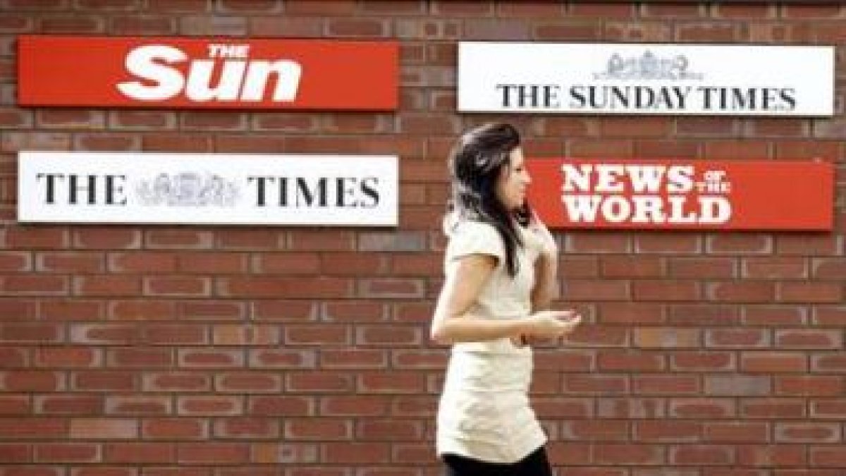 Una mujer pasa delante de la sede de la empresa editora de -˜News International-™.