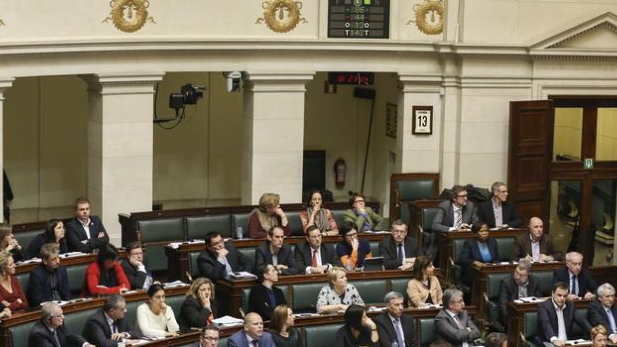 Los parlamentarios belgas, con la imagen de pantalla que publica los resultados de la votación aprobada de la eutanasia para los menores, en febrero del 2014.