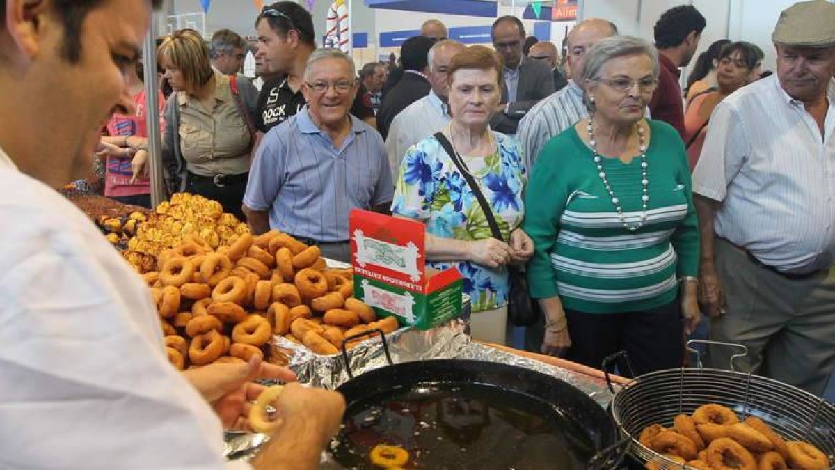 Un confitero prepara sus rosquillas ante los visitantes de la feria.