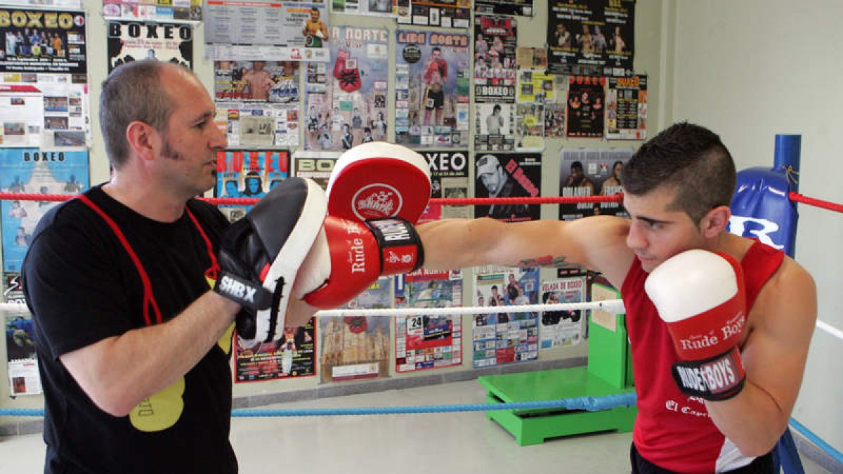 Alfredo Arrojo, a la izquierda, enseña el arte del boxeo a un joven púgil. MARCIANO PÉREZ