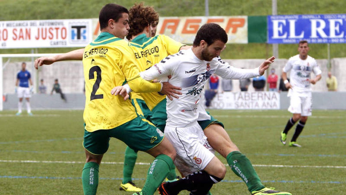 El futbolista georgiano Iakob, a la derecha, trata de irse de tres contrarios en un lance del partido disputado en el campo de Santa Ana