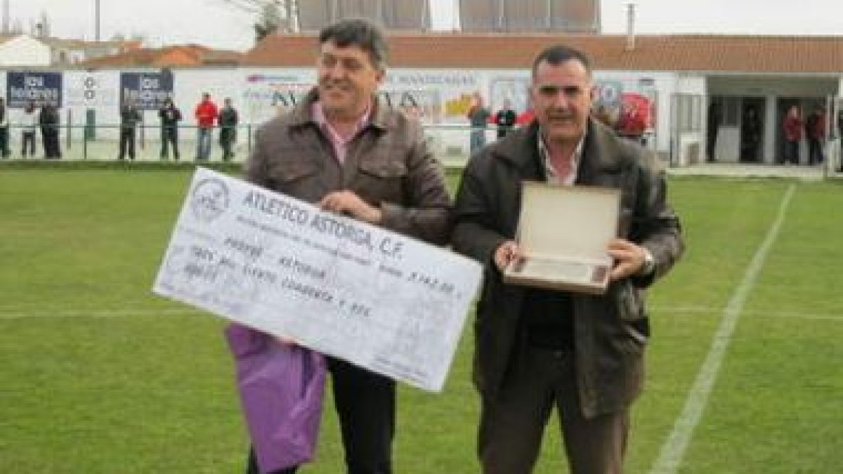 Jorge Alija (i) entrega el cheque de 3.142 euros a Francisco Mateo.