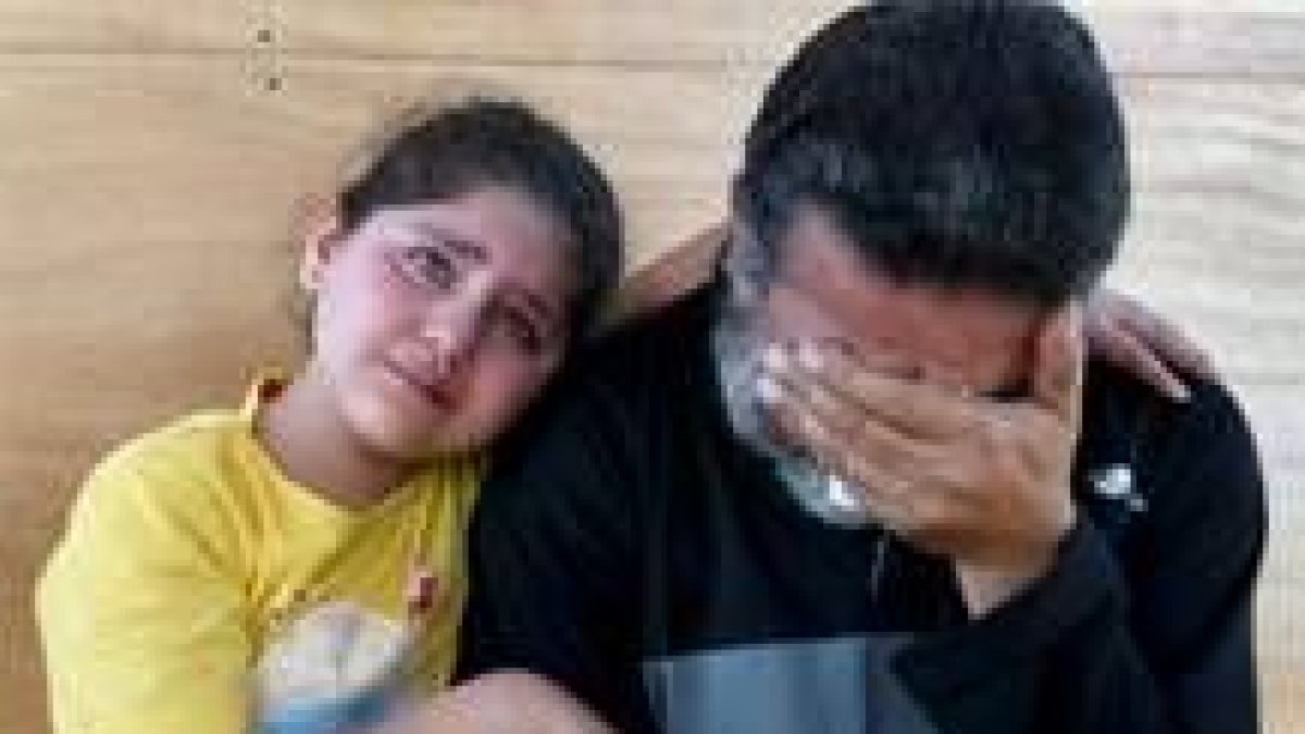 Una niña iraquí consuela a su padre tras visitar a unos familiares en la cárcel Abu Graib