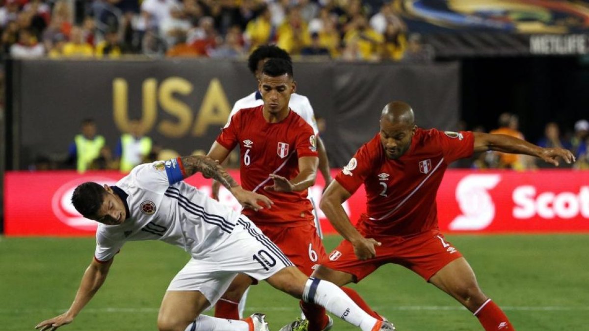 El colombiano James Rodriguez pugna por el balón con los peruanos Alberto Rodriguez y Miguel Trauco.
