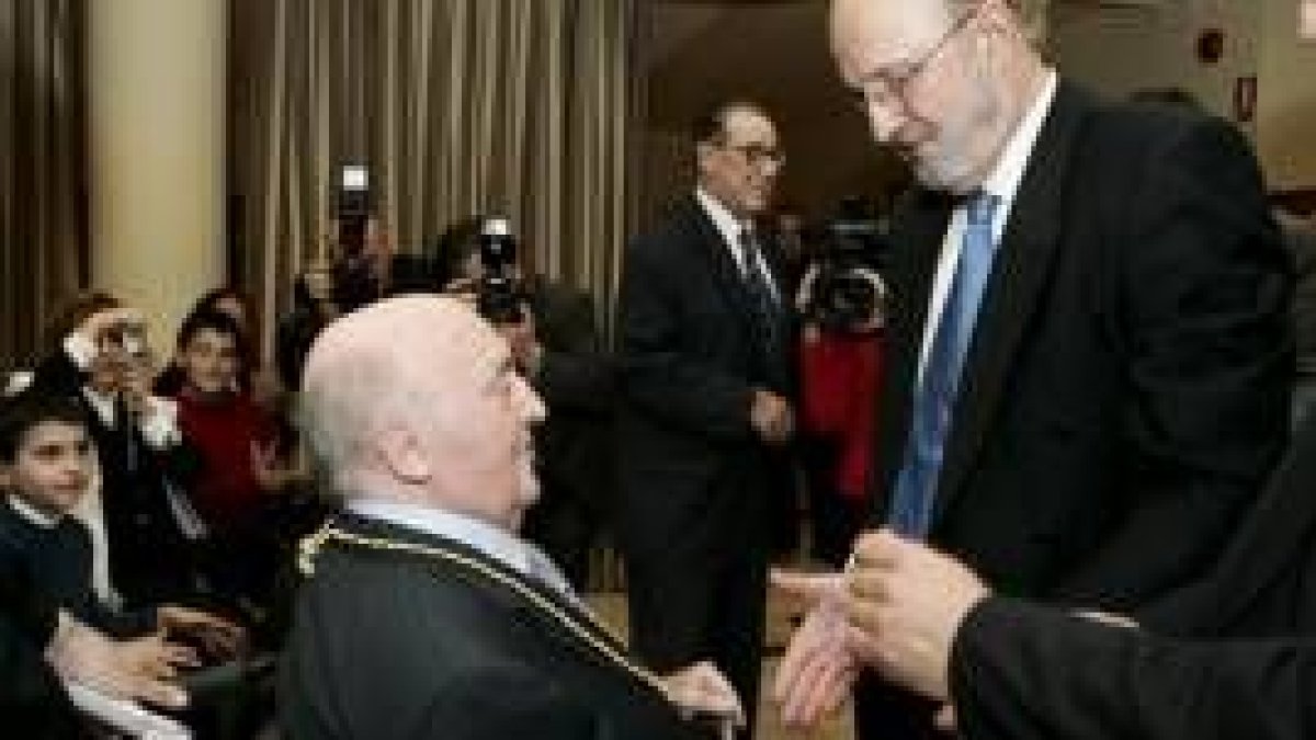 El presidente del Colegio de Economistas, Roberto Escudero, impone la medalla a Fabián Estapé