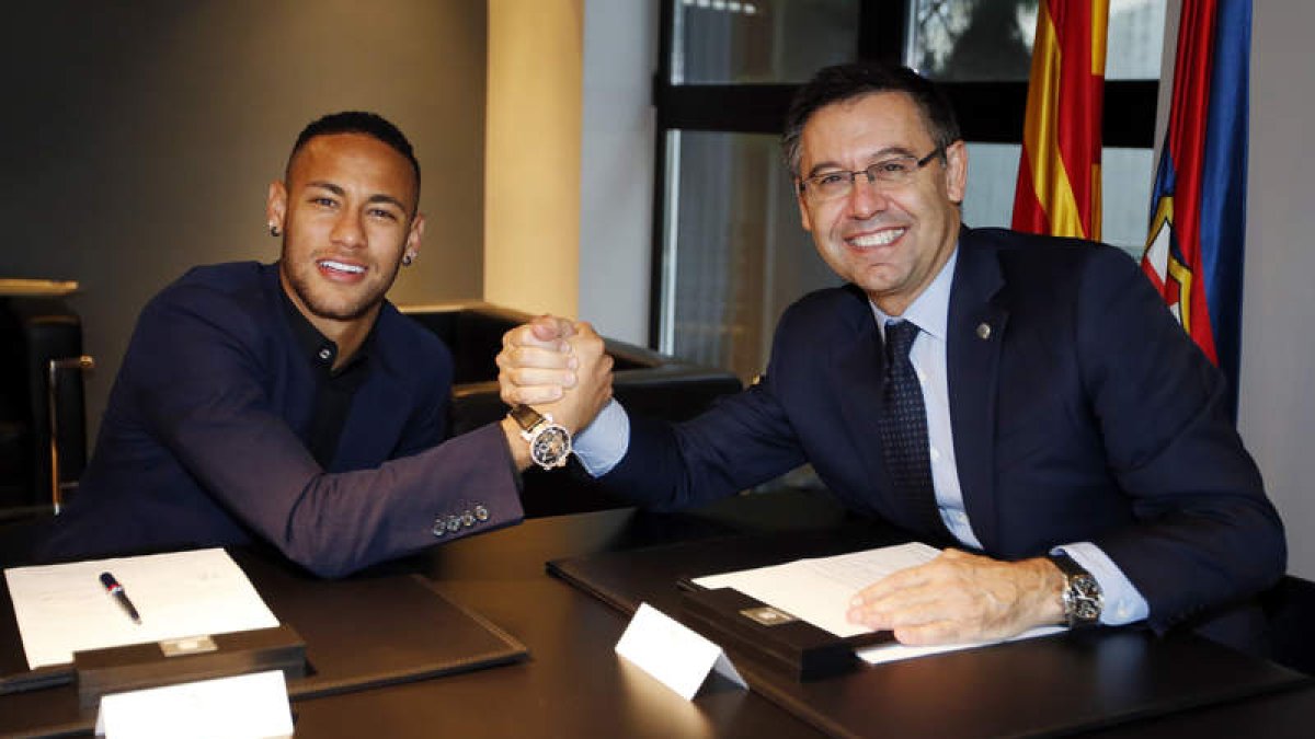 Neymar estrecha la mano con su presidente Josep María Bartomeu tras firmar su renovación. FCB
