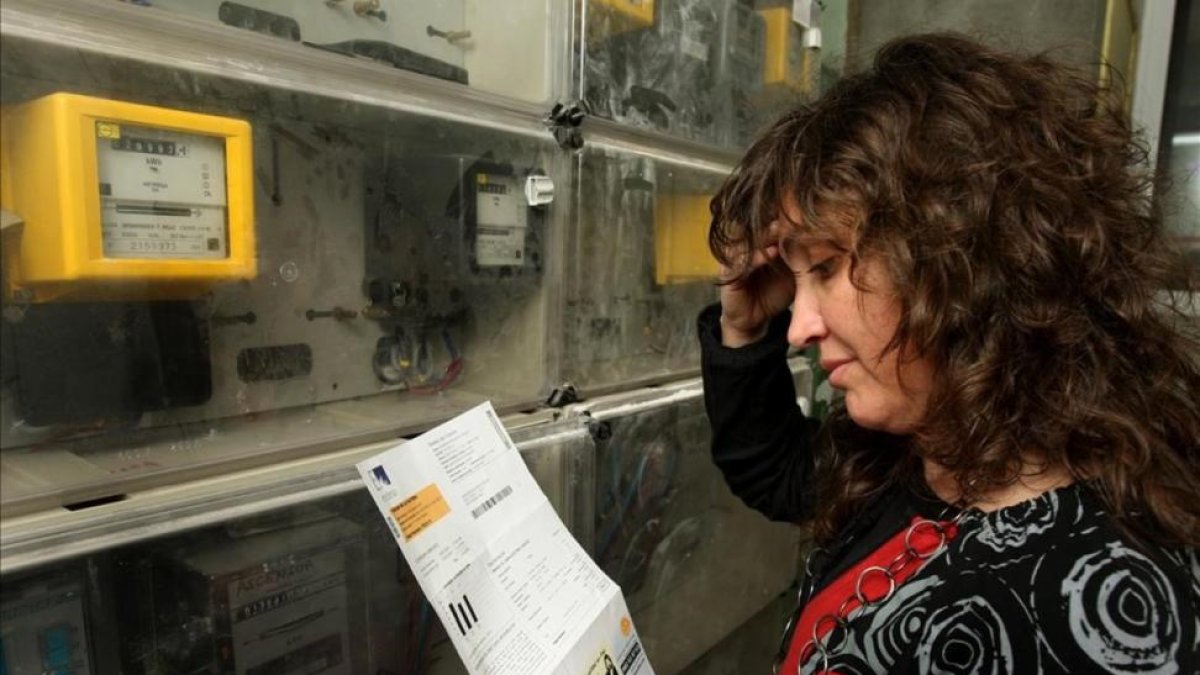 Una mujer comprueba la lectura del contador de electricidad.