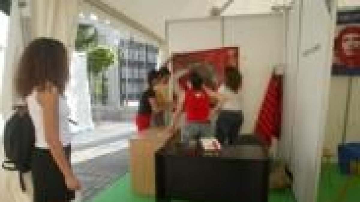 Unos jóvenes preparan uno de los stands de Expoxoven