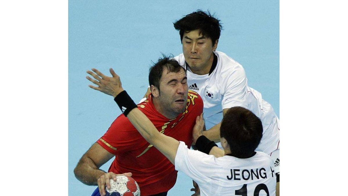 El español Joan Canellat, junto a los surcoreanos Lim Duk-jun y Jeong Han en el partido preliminar de balonmano