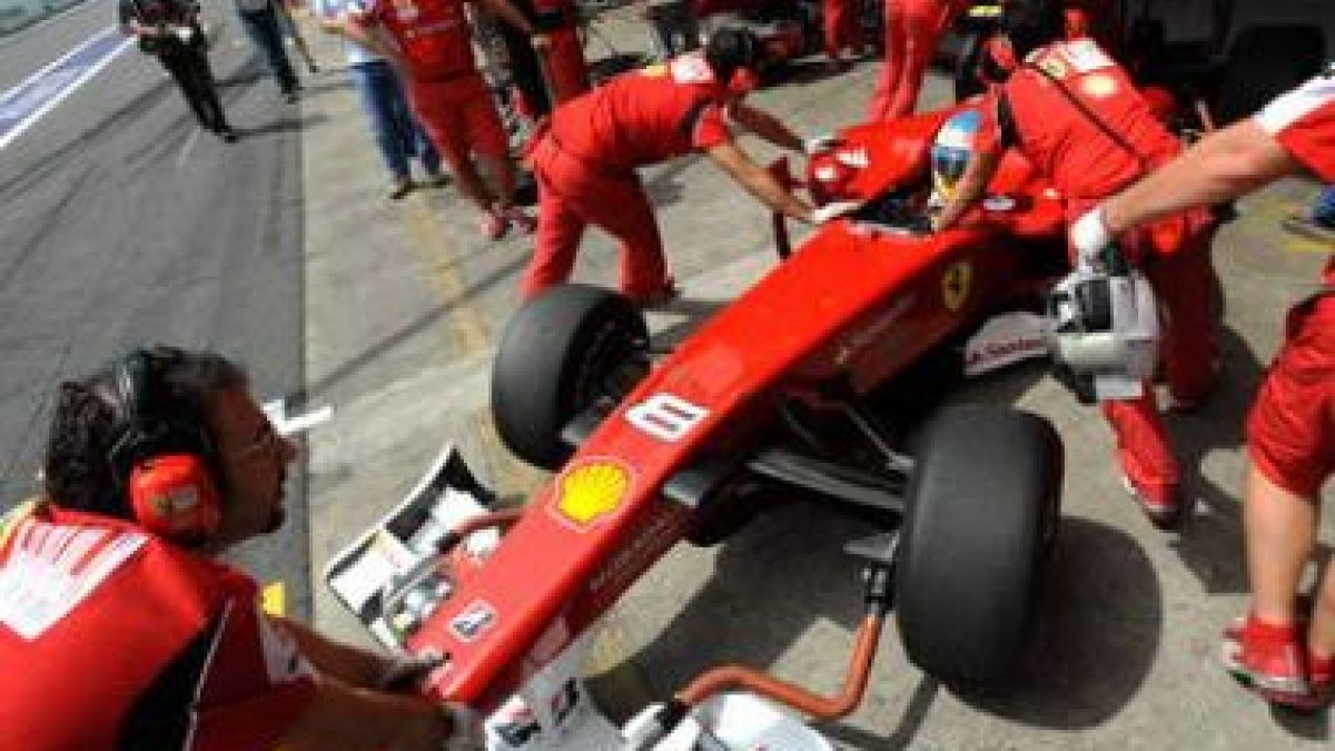 Mecánicos de Ferrari preparan el coche de Fernando Alonso.