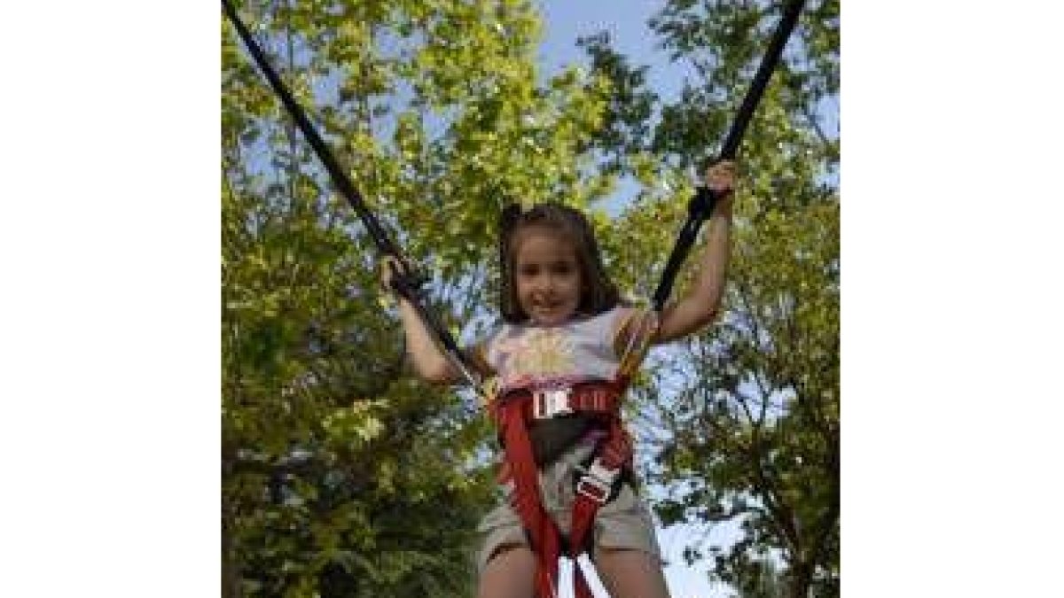 Una niña disfruta de la cama elástica