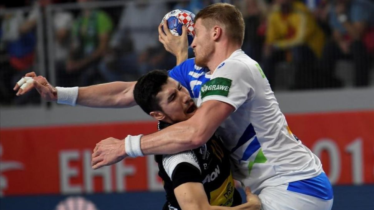 El lateral español Alex Dujshebaev choca contra el pivote esloveno Blagotinsek