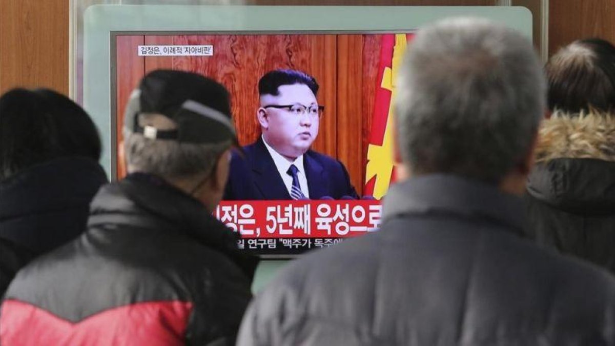 Un grupo de surcoreanos miran el discurso de fin de año del líder norcoreano Kim Jong-un en una televisión de una estación de tren de Seúl.
