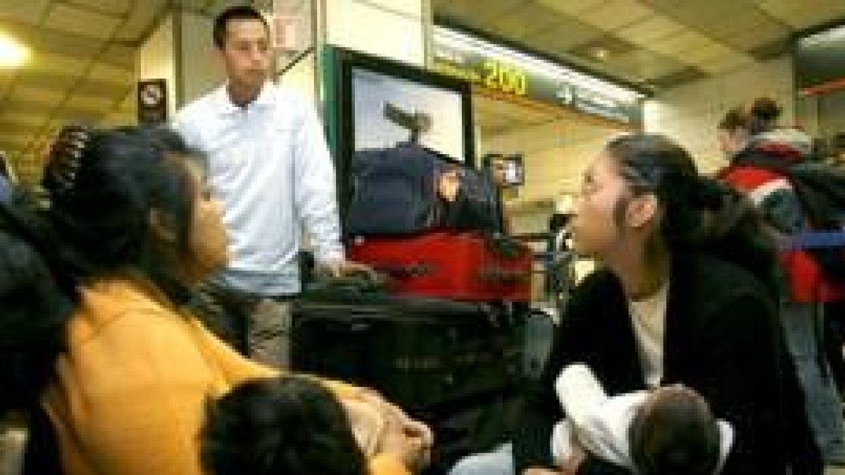 Un grupo de viajeros ecuatorianos esperan en la Terminal 1 de Barajas