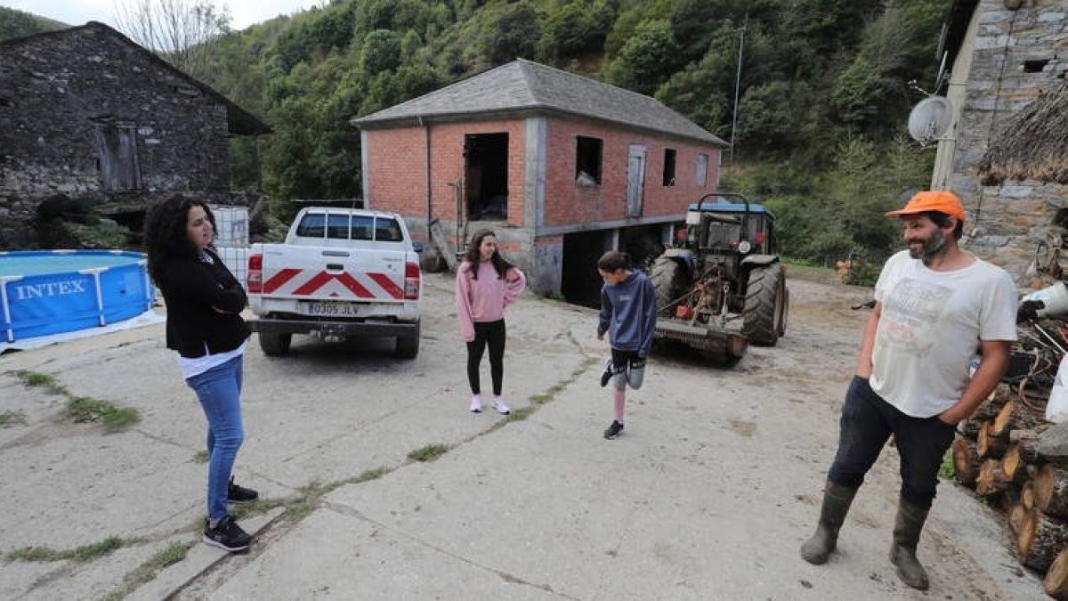Carmel Pol y Óscar Juanes, con sus dos hijas (centro), en la plaza del pueblo de Bargelas, municipio de Vega de Valcarce. ANA F. BARREDO