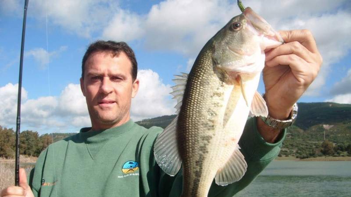 Un pescador muestra un buen ejemplar de black bass o perca negra.