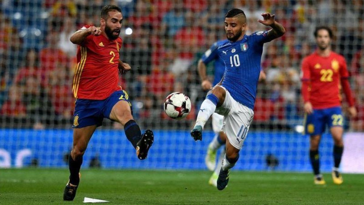 Carvajal e Insigne pugnan por un balón en el partido España-Italia de clasificación para el Mundial de Rusia.