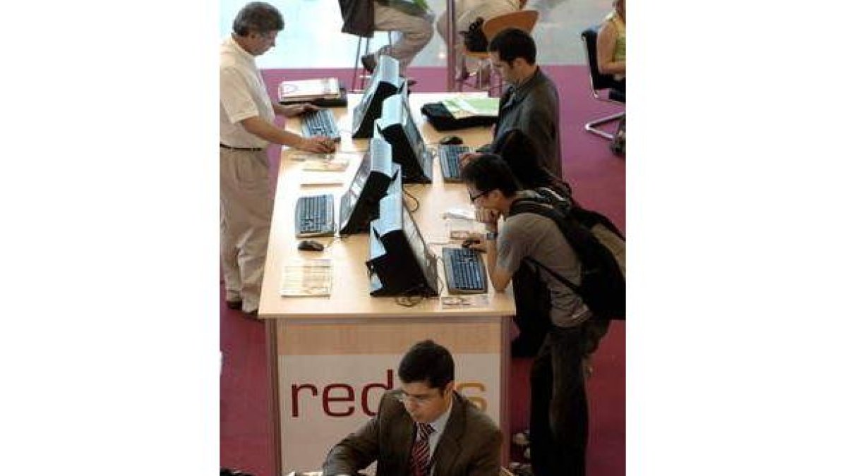 Varias personas navegan por Internet en un espacio equipado con varios ordenadores.