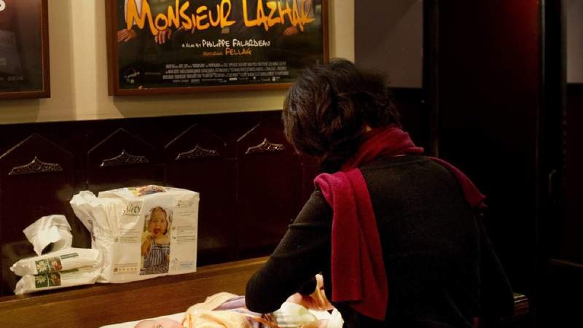 Una mujer cambiando el pañal a un bebé.