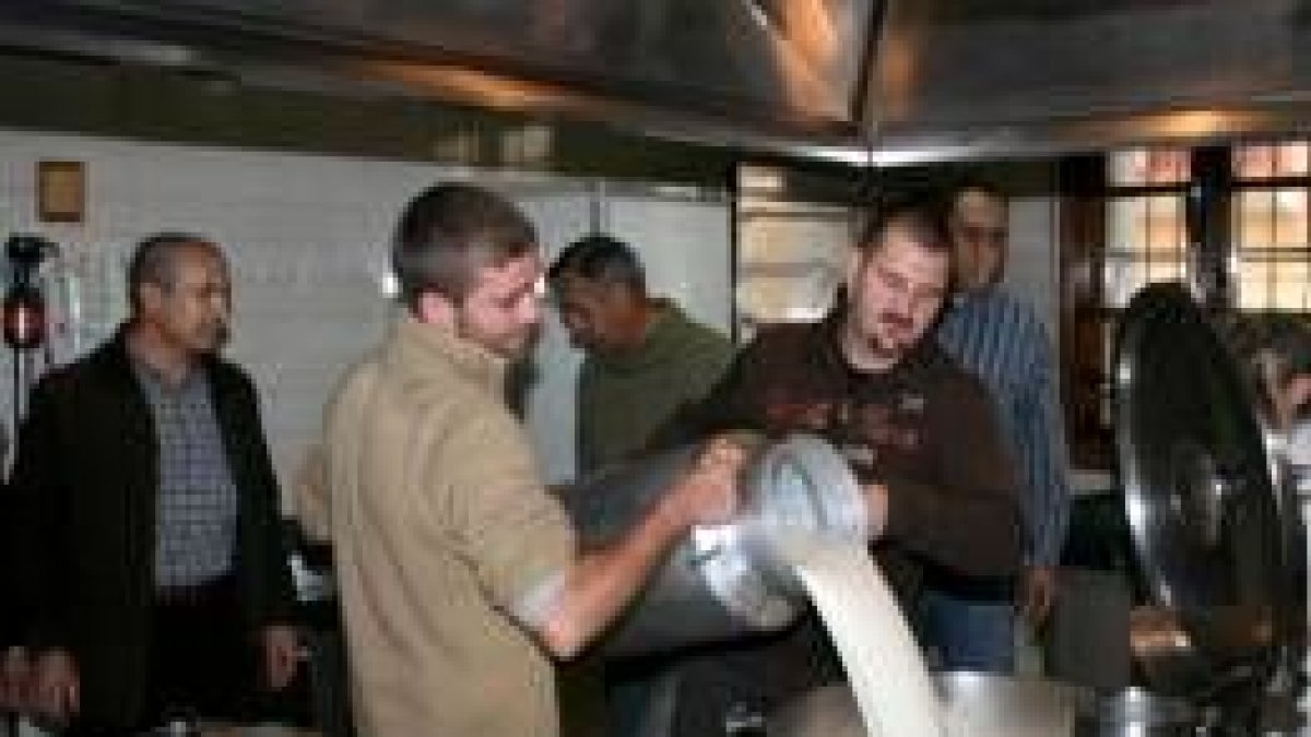 Los productores entregan leche en la cocina de Cáritas