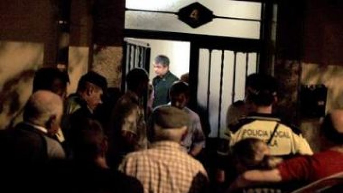 Policías, familiares y vecinos aguardan la retirada de los cadáveres.
