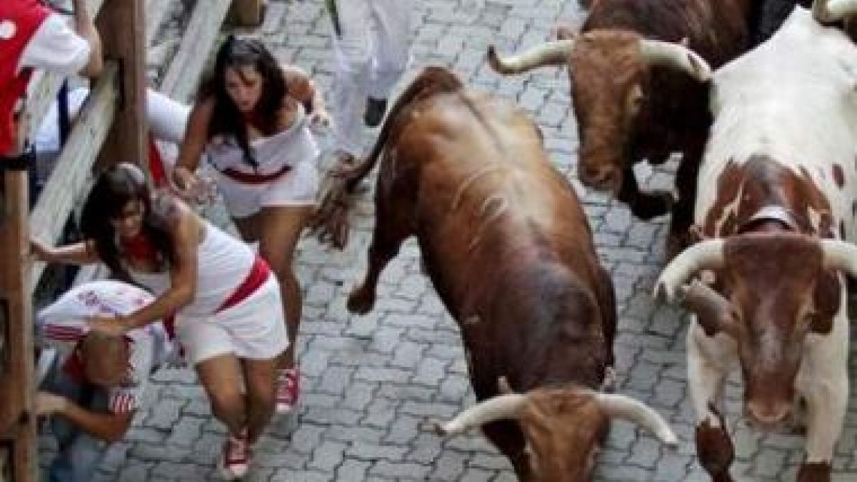 Un toro puso en apuros a las dos jóvenes que a su derecha intentan meterse tras el vallado.