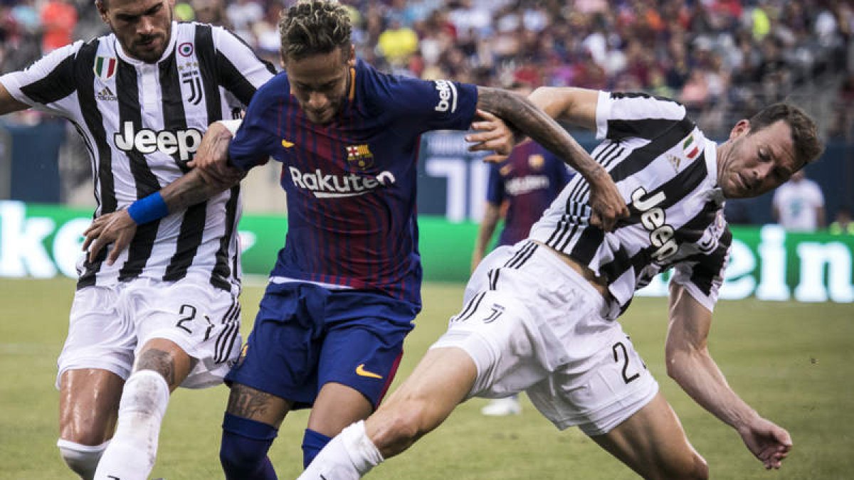 Neymar intenta zafarse de dos futbolistas de la Juventus en el amistoso del domingo. EDU BAYER